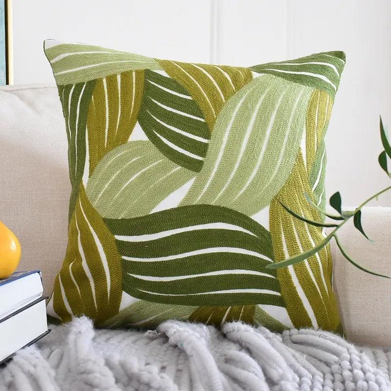 Nature-inspired decorative cushion cover featuring green leaf embroidery design